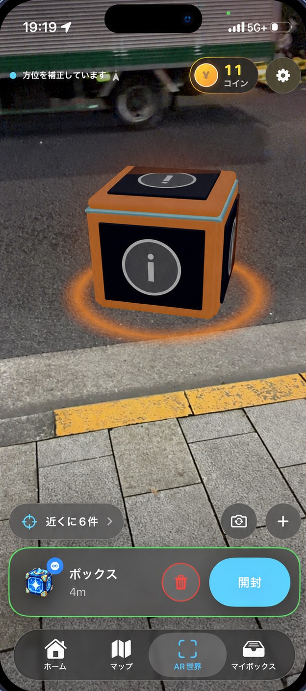 AR世界で、歩道の上に光のボックスが現れている画面
